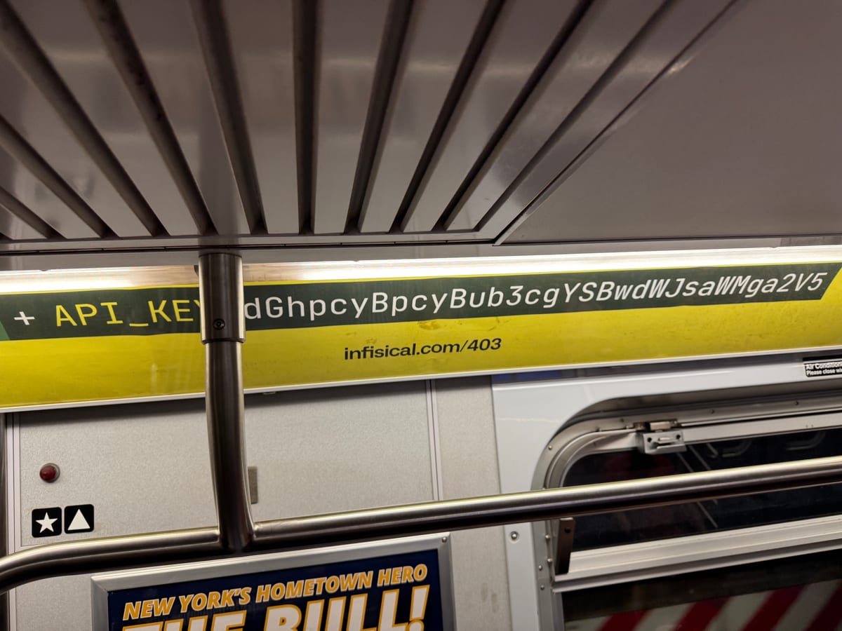 The ad in place: a yellow strip above the subway car windows with a dark band carrying a single monospaced line, API_KEY equals a long string, and the URL infisical.com/403 beneath it.